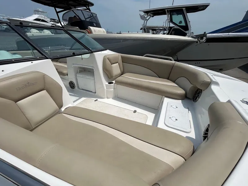 Slide: The Image of 2021 NauticStar 203 DC boat interior with beige seating and modern design. - 3