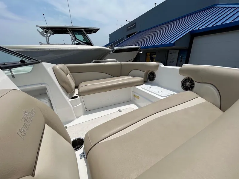 Slide: The Image of 2021 NauticStar 203 DC boat interior with beige seating and cup holders. - 4