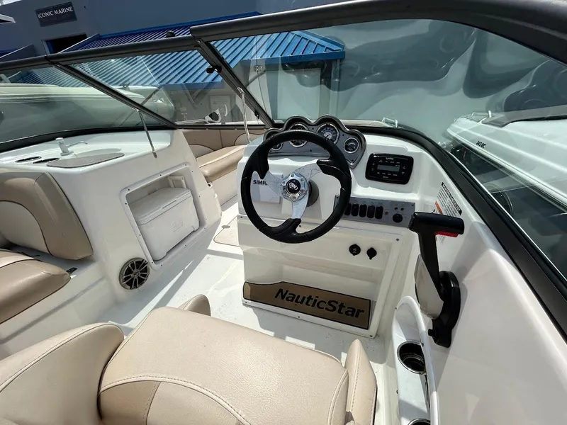 Slide: The Image of 2021 NauticStar 203 DC boat interior with steering wheel and beige seating. - 5