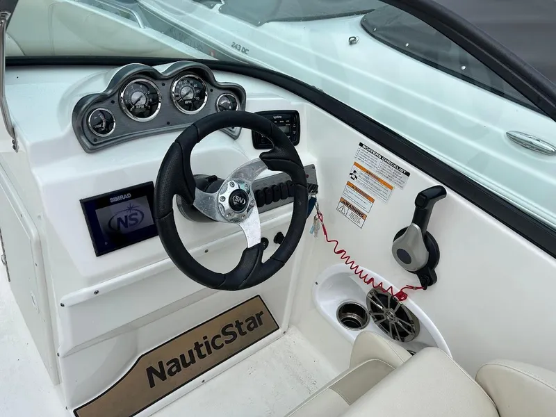 Slide: The Image of 2021 NauticStar 203 DC boat dashboard with steering wheel and control panel. - 6