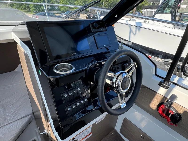 Slide: The Image of 2025 Jeanneau NC 795 Series 2 boat dashboard with steering wheel and navigation display. - 12