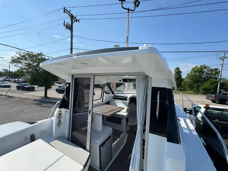 Slide: The Image of 2025 Jeanneau NC 795 Series 2 boat with open cabin and seating area. - 4