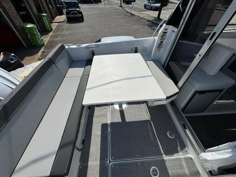 Slide: The Image of 2025 Jeanneau NC 795 Series 2 boat interior with seating and table setup. - 5