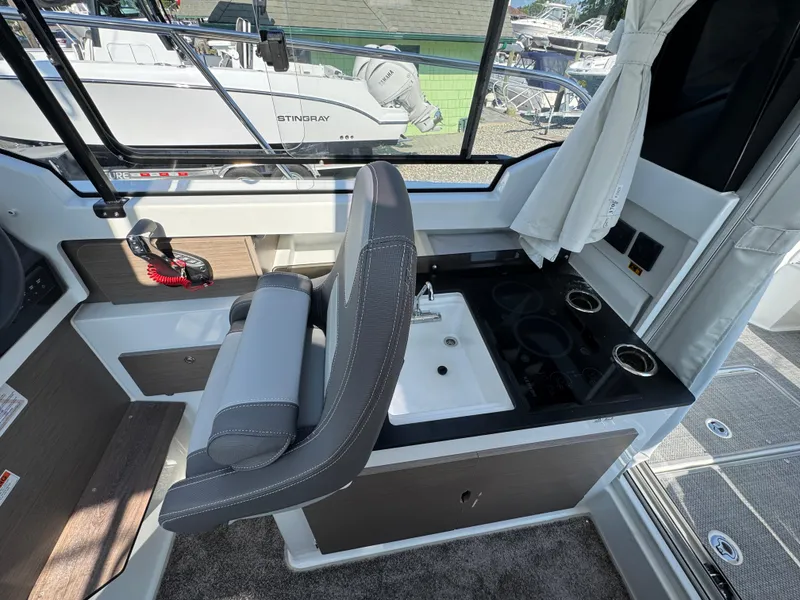 Slide: The Image of 2025 Jeanneau NC 795 Series 2 boat interior with helm, sink, and stove. - 9