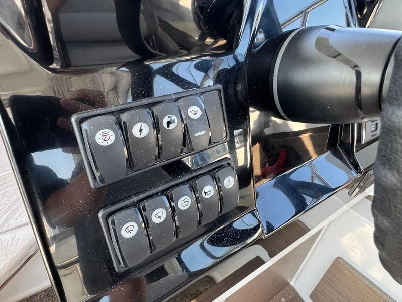 Slide: The Image of Control panel of 2025 Jeanneau NC 795 Series 2 boat with various switches. - 14