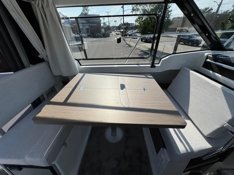 Slide: The Image of Interior of 2025 Jeanneau NC 795 Series 2 boat with dining area and large window. - 16