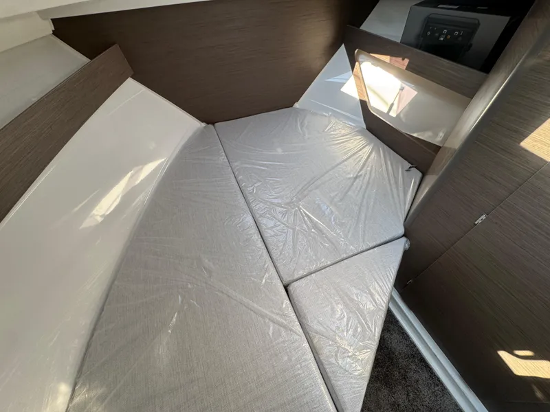 Slide: The Image of 2025 Jeanneau NC 795 Series 2 cabin interior with cushioned bed and modern design. - 19