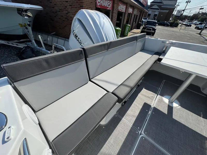 Slide: The Image of 2025 Jeanneau NC 795 Series 2 boat interior with cushioned seating and table. - 2