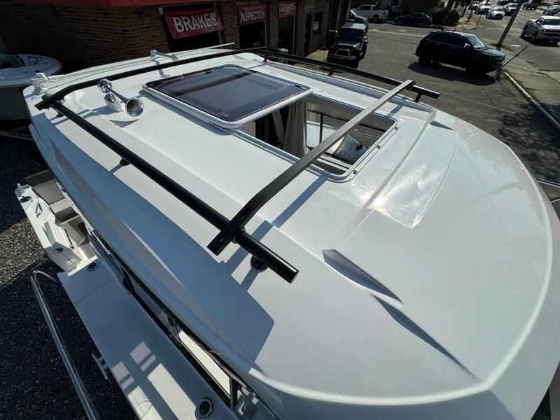 Slide: The Image of 2025 Jeanneau NC 795 Series 2 boat roof with sunroof and railings, parked outdoors. - 23