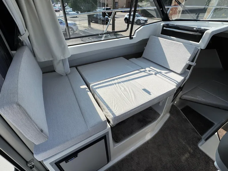 Slide: The Image of Interior seating of 2025 Jeanneau NC 795 Series 2 boat, featuring convertible cushions. - 24
