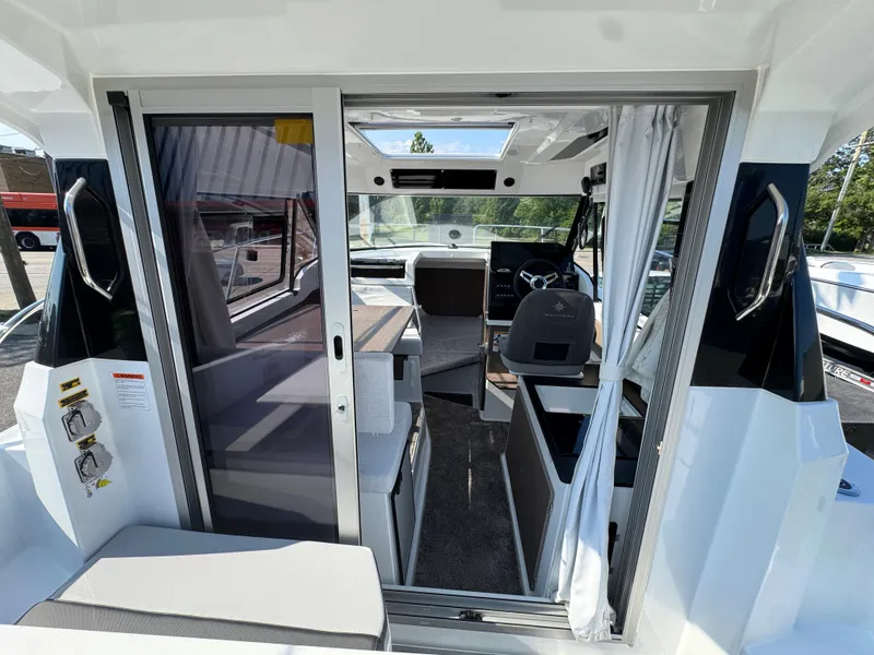 Slide: The Image of 2025 Jeanneau NC 795 Series 2 boat interior with modern seating and steering area. - 6