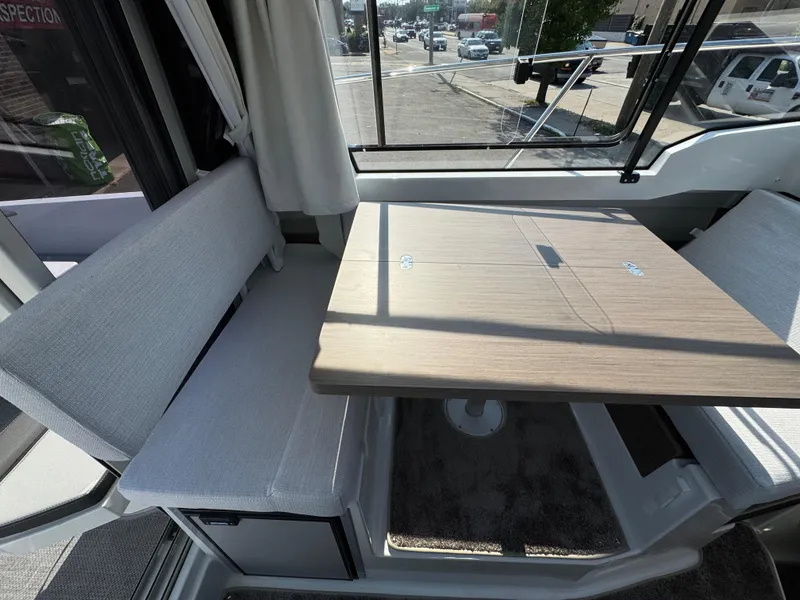 Slide: The Image of Interior of 2025 Jeanneau NC 795 Series 2, featuring a cozy dining area with a wooden table. - 8