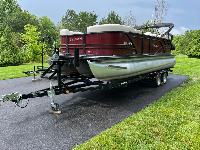 Slide: The Image of 2021 Sylvan Mirage X X3 pontoon boat on trailer, parked on driveway. - 2