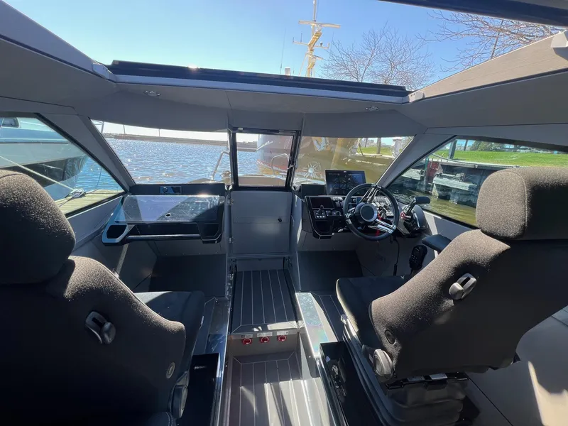 Slide: The Image of 2024 G-Force boat interior with modern cockpit and dual seats, overlooking a serene waterfront. - 9