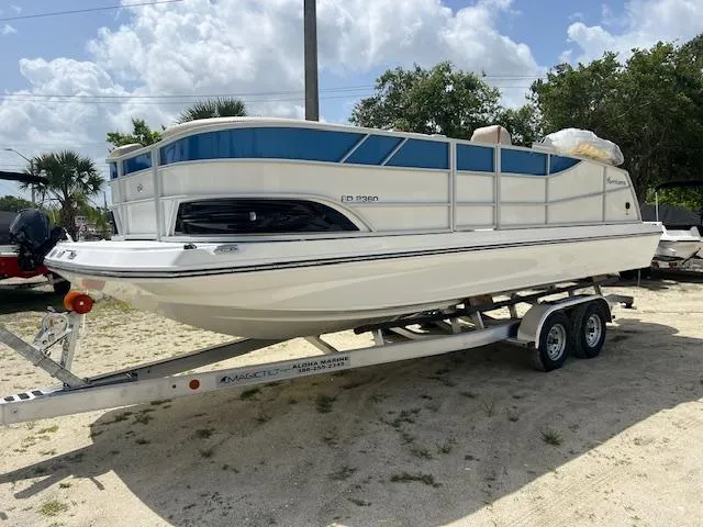 The Image of 2025 Hurricane FunDeck 2360 SBC OB boat on trailer, parked outdoors. - 0