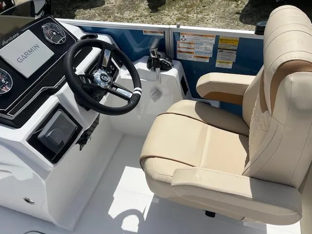 Slide: The Image of 2025 Hurricane FunDeck 2360 SBC OB boat cockpit with Garmin navigation and beige captain's chair. - 3