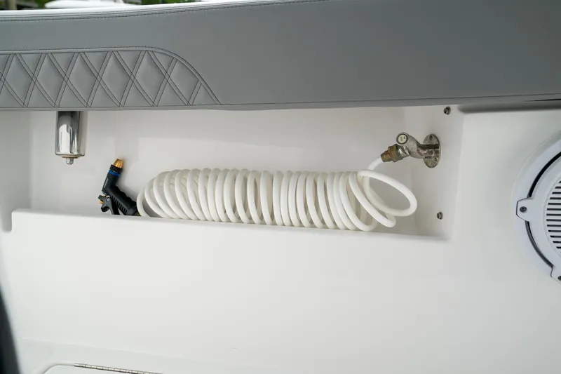 Slide: The Image of Coiled hose in storage compartment of 2026 Front Runner 33 CC boat. - 33