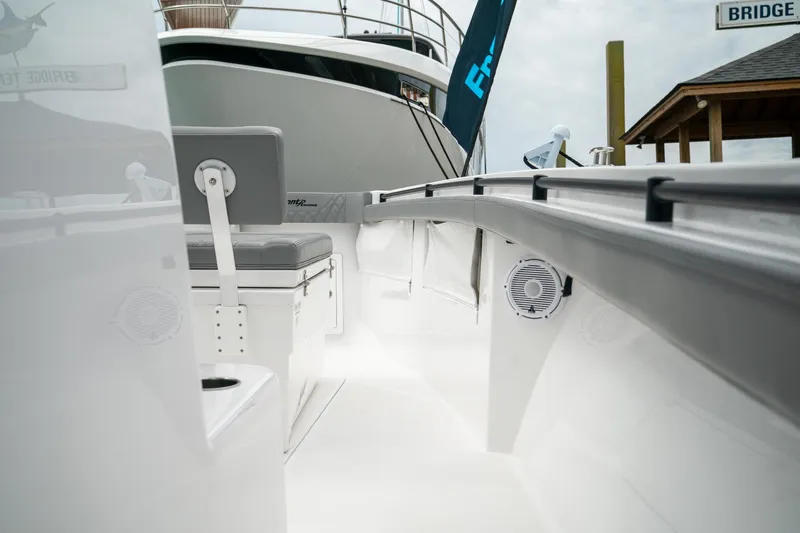 Slide: The Image of 2026 Front Runner 33 CC boat interior with seating and speakers, docked near a larger vessel. - 34