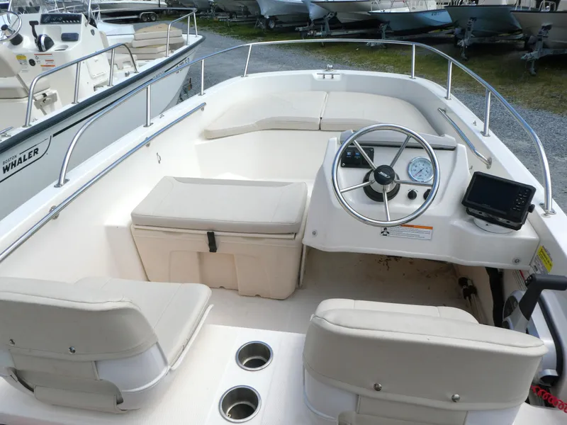 Slide: The Image of 2024 Boston Whaler 160 Super Sport interior with steering wheel and seating. - 3