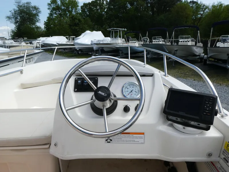 Slide: The Image of 2024 Boston Whaler 160 Super Sport dashboard with steering wheel and navigation display. - 5