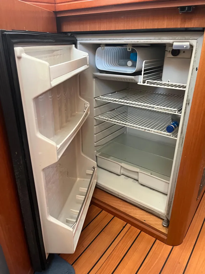 Slide: The Image of Open fridge inside 2007 Beneteau Oceanis Clipper 343 yacht, showing empty shelves. - 36