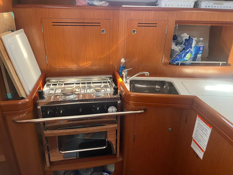Slide: The Image of 2007 Beneteau Oceanis Clipper 343 yacht kitchen with stove, sink, and wooden cabinetry. - 39