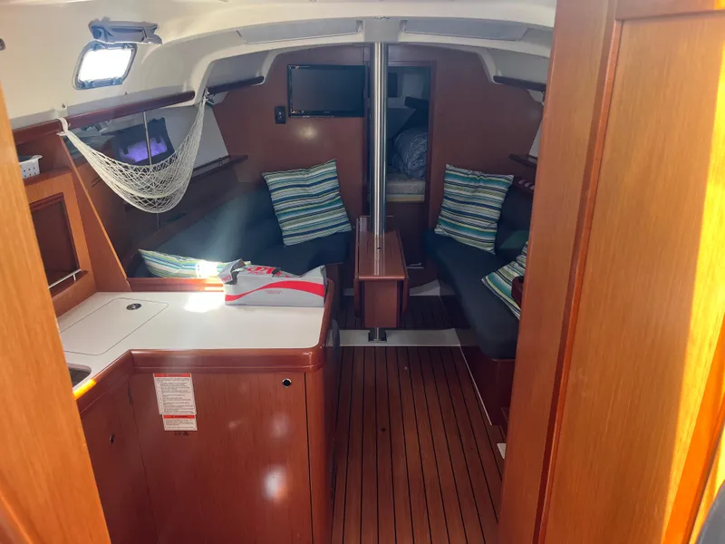 Slide: The Image of Interior of 2007 Beneteau Oceanis Clipper 343 sailboat with cozy seating and striped cushions. - 9