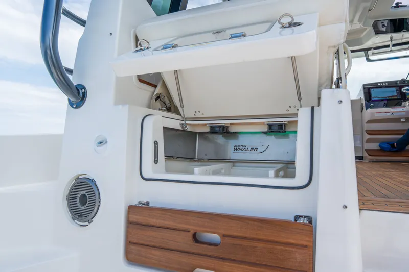 Slide: The Image of Boston Whaler 405 Conquest 2026, interior storage with wood accents. - 16