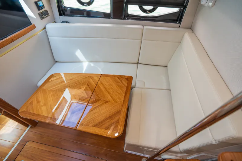 Slide: The Image of Interior of 2026 Boston Whaler 405 Conquest with wooden table and white seating. - 43