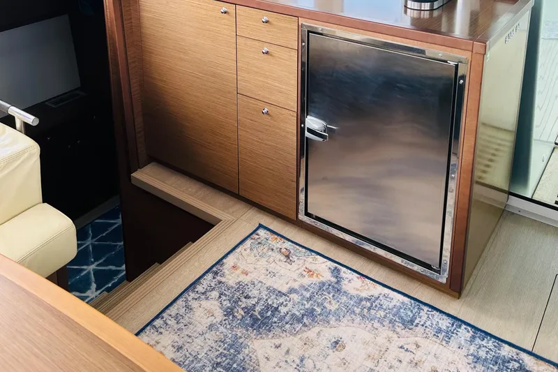 Slide: The Image of Interior of 2019 Lagoon 450 F Owner's Edition yacht with wooden cabinetry and stainless steel fridge. - 25