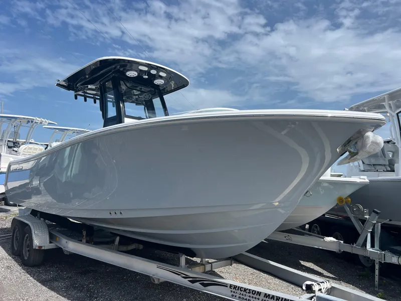 The Image of 2025 Sportsman Open 232 Center Console boat on trailer under blue sky. - 0