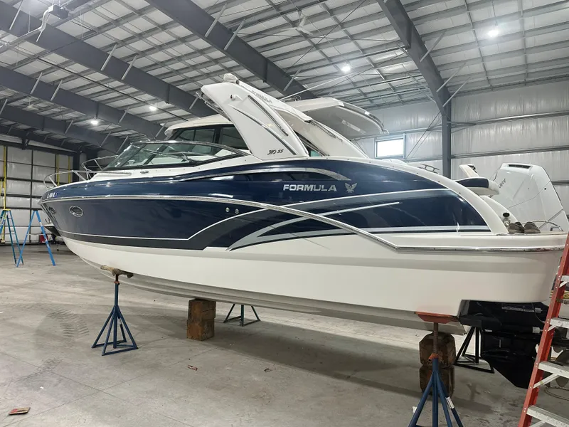 Slide: The Image of 2018 Formula 310 Sun Sport boat in a warehouse, elevated on stands. - 2