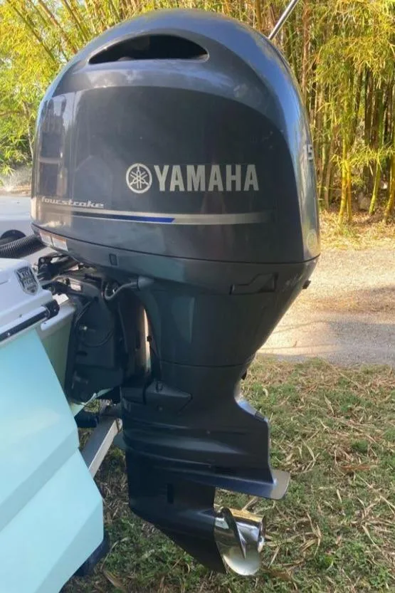 Slide: The Image of Yamaha outboard motor on 2016 Robalo 206 Cayman boat, parked outdoors. - 12