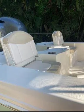 Slide: The Image of 2016 Robalo 206 Cayman boat interior with seating and console, surrounded by lush greenery. - 9