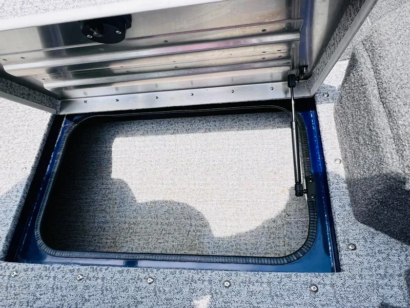 Slide: The Image of 2023 Tracker Pro Guide V-175 WT storage compartment with open hatch, showcasing interior space. - 23