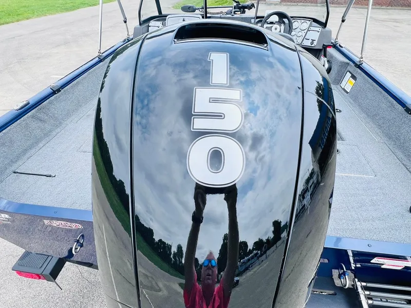 Slide: The Image of 2023 Tracker Pro Guide V-175 WT boat with 150 HP engine, reflecting sky and person. - 42