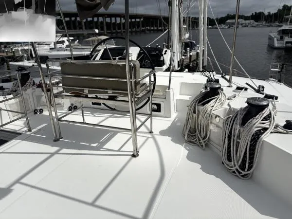Slide: The Image of 2012 Lagoon 560 yacht deck with ropes and seating, docked at marina. - 23