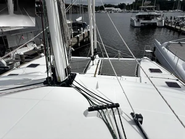 Slide: The Image of 2012 Lagoon 560 catamaran docked at marina, showcasing deck and rigging. - 24