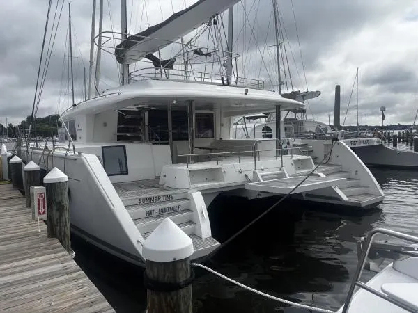 Slide: The Image of 2012 Lagoon 560 catamaran docked at marina under cloudy skies. - 29