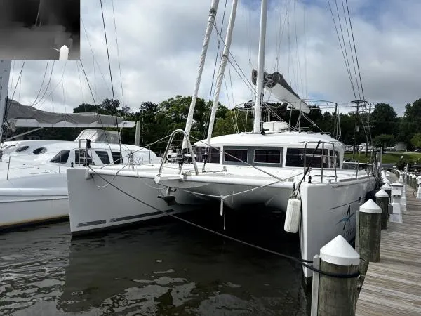 Slide: The Image of 2012 Lagoon 560 catamaran docked at a marina under cloudy skies. - 30