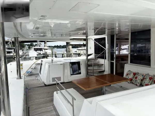 Slide: The Image of Spacious deck of 2012 Lagoon 560 yacht with seating and table, docked at marina. - 5