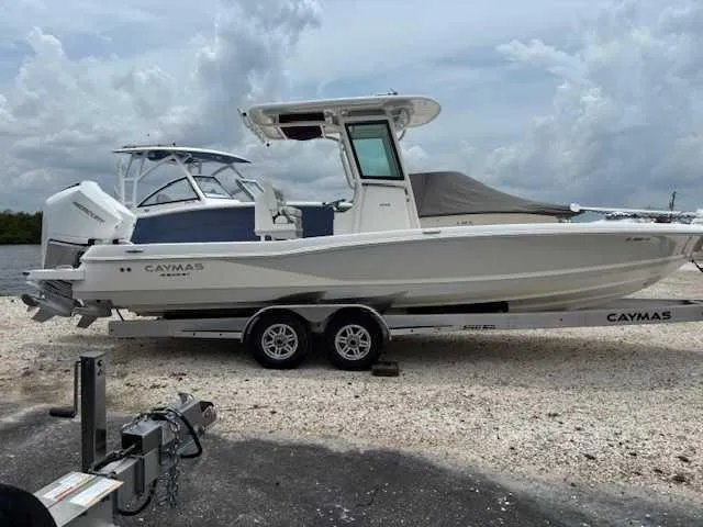 Slide: The Image of 2022 Caymas 28 Twin boat on trailer, parked outdoors under cloudy sky. - 12