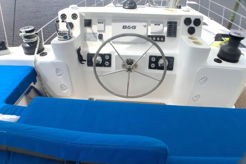 Slide: The Image of Helm of 2021 Royal Cape Catamarans Majestic 570 Flybridge with blue seating and navigation controls. - 22