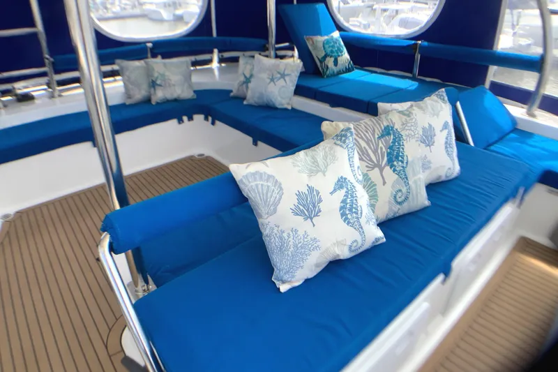 Slide: The Image of Luxurious seating area on 2021 Royal Cape Catamarans Majestic 570 Flybridge with blue cushions and nautical pillows. - 23