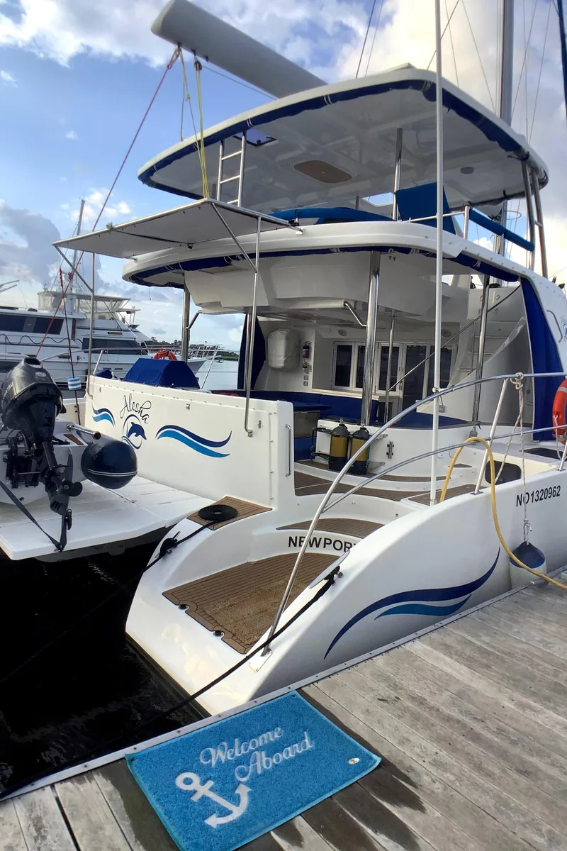 Slide: The Image of Royal Cape Catamarans Majestic 570 Flybridge 2021 docked, featuring a welcoming mat and sleek design. - 9