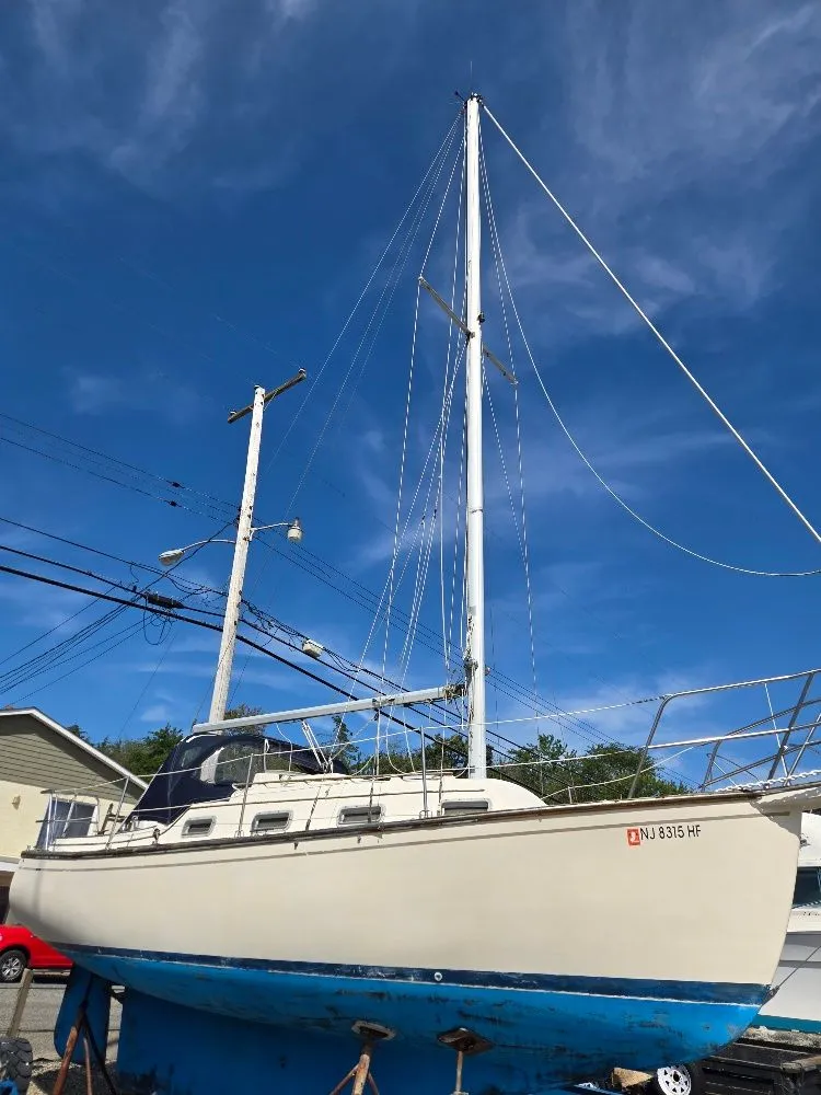 Slide: The Image of 1986 Island Packet IP27 sailboat on land, blue hull, clear sky background. - 10