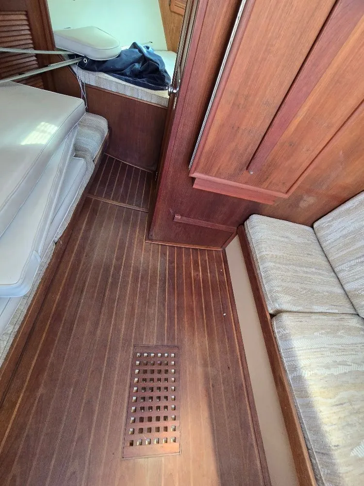 Slide: The Image of Interior of 1986 Island Packet IP27 sailboat with wooden flooring and cushioned seating. - 11