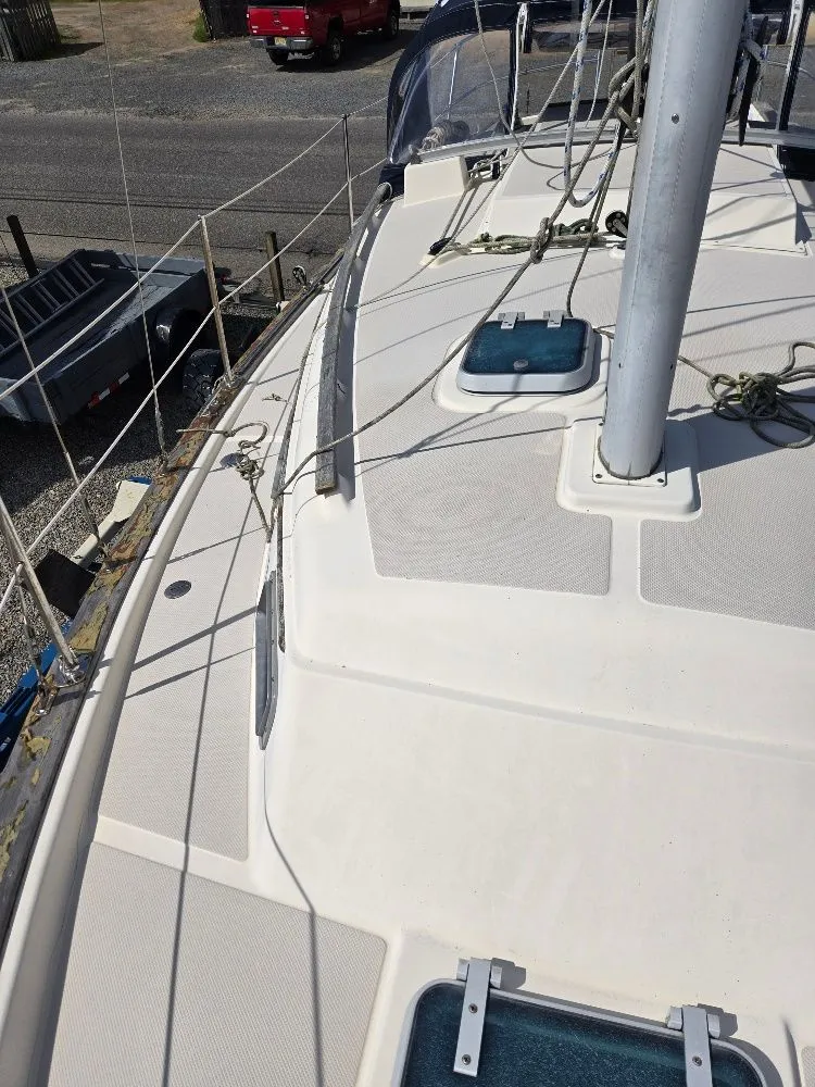 Slide: The Image of 1986 Island Packet IP27 sailboat deck with mast and rigging, docked at a marina. - 15