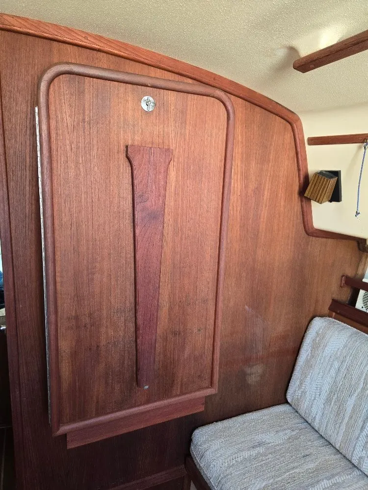 Slide: The Image of Interior of 1986 Island Packet IP27 sailboat with wooden paneling and cushioned seating. - 4