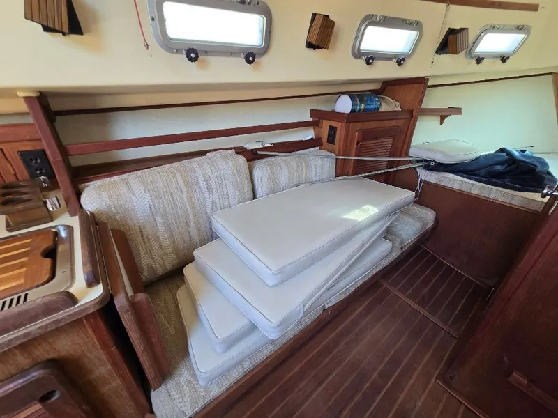 Slide: The Image of Interior of 1986 Island Packet IP27 sailboat with cushions and wooden cabinetry. - 6